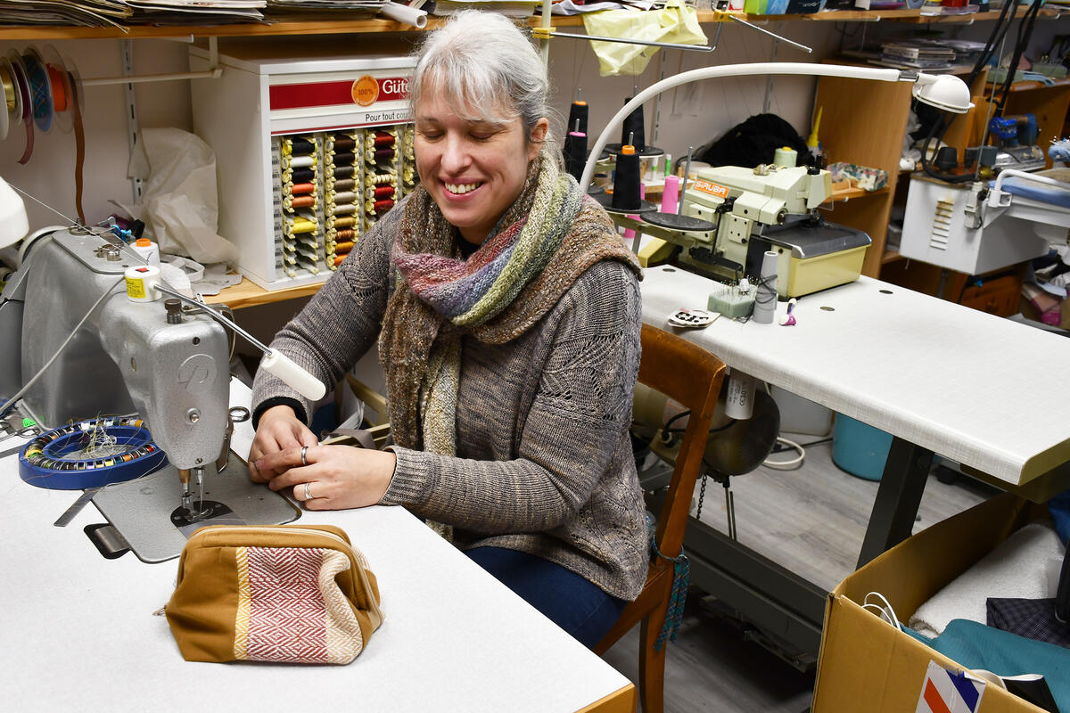 Le métier à tisser est installé devant la fenêtre, avec une vue sur la campagne. La bande posée sur le métier est terminée. C'est dedans que seront découpées les pièces pour réaliser les pochettes. 