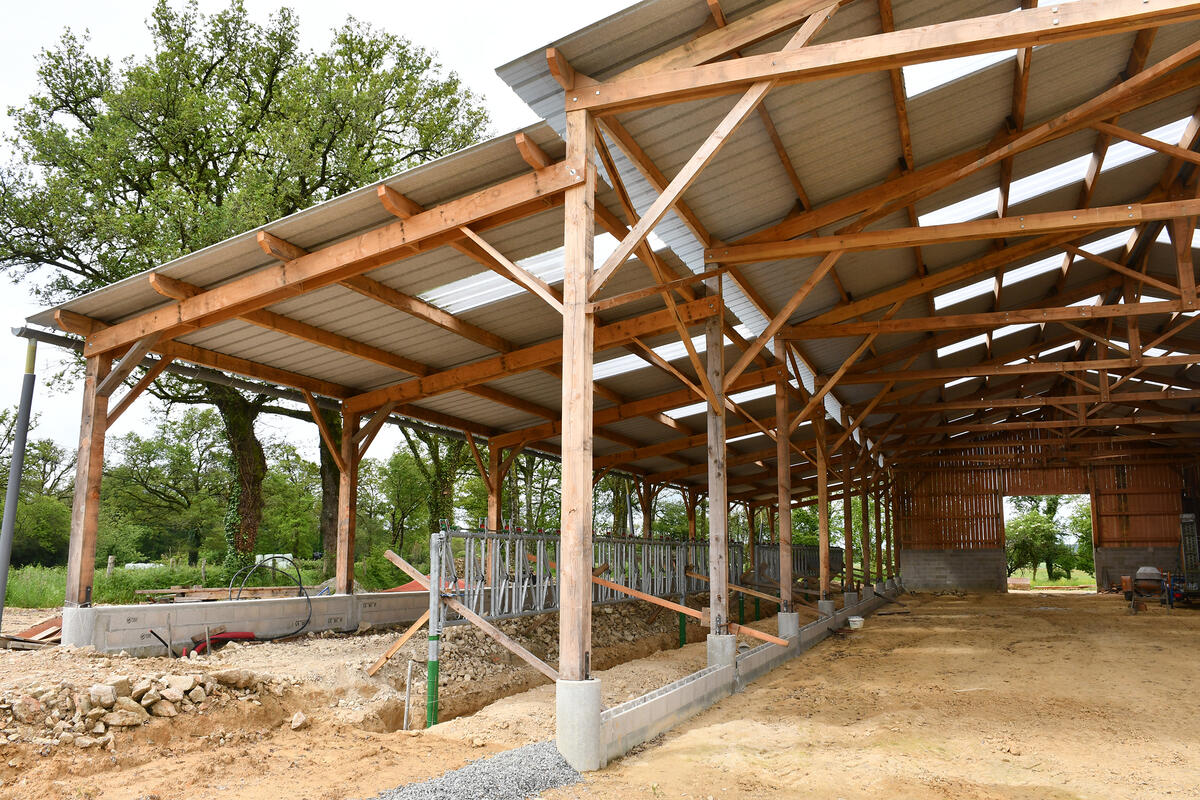 Guillaume Gauthier et Sara Malissard, chargée de mission au GLBV qui a géré la demande d'aide dans le cadre d'un PCAE. Ils sont devant l'appentis encore en travaux où les vaches viendront manger. 